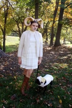 a woman with horns is standing next to a dog