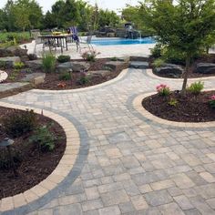 an outdoor patio area with stone pavers and landscaping