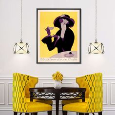 a dining room with two yellow chairs and a painting hanging on the wall above it