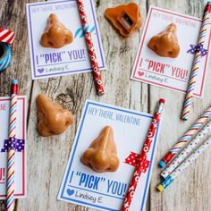 valentine's day treats are arranged on a wooden table with candy sticks and candies