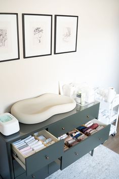 a table with drawers and pictures on the wall