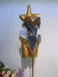 a mannequin with gold fringes on it's head and dress form