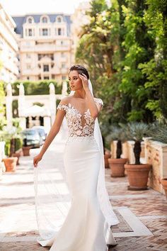 a woman in a wedding dress is walking down the street