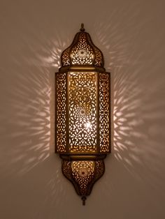 an intricately designed wall light casts a shadow on the wall