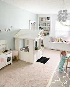 a child's bedroom with a white doll house and toys in the room on the floor