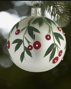 a white ornament with red berries and green leaves