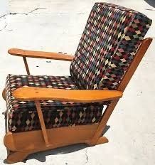 a wooden rocking chair sitting on top of a cement floor