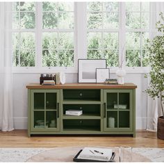 a living room with a large window and a green entertainment center in front of it