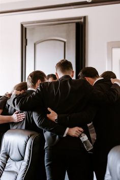 a group of people in suits hugging each other