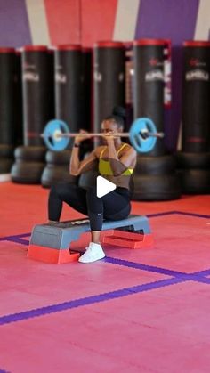 a woman squats on a bench while holding a barbell in front of her