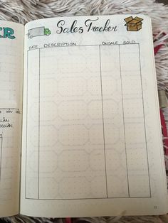 an open notebook with sales tracker on the page and other items in it sitting on top of a rug