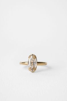 a yellow gold ring with an oval cut diamond