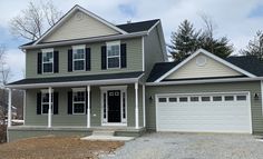 a two story house with white trim and black shutters