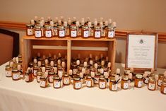 a table topped with lots of jars filled with honey next to a sign that reads