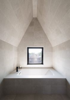 an empty bathroom with a window and bathtub