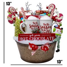 a christmas gift basket with coffee mugs, candy and candies in it is shown