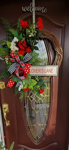 a welcome sign hangs on the front door of a home decorated for valentine's day