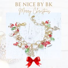 a christmas bracelet with red bows and bells on it, sitting next to a glass ornament