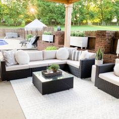 an outdoor living area with couches and tables