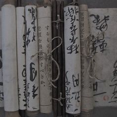 several chinese writing on paper tied to wooden poles