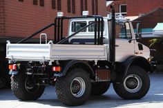 a white truck parked in front of a brick building