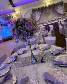 the table is set with purple flowers and silver sequins for an elegant wedding reception