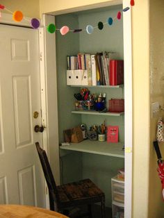 a book shelf with many books on it in a room next to a table and door