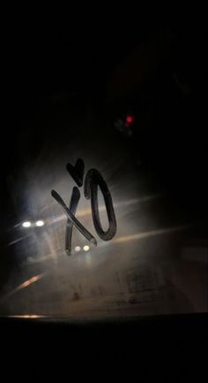 the word xo spelled out in front of a car at night