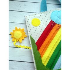 a colorful bag with a sunflower on the side and a felt flower in the middle