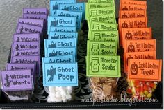 there are many halloween treats on display in the trays with name tags attached to them