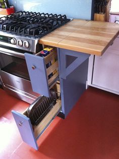 an open drawer in the middle of a kitchen counter next to a stove top oven