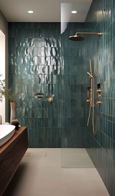 a bathroom with green tiles and gold fixtures on the shower head, tub, and sink