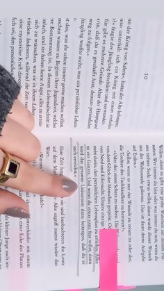 a woman's hand holding onto a book with a cross on the page next to it