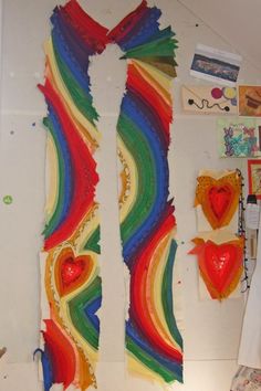 the wall is covered in colorful paper and other art work, including heart shaped pieces