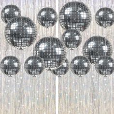 several shiny disco balls hanging from a curtain