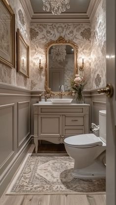 a white toilet sitting under a bathroom mirror next to a sink and a vanity in a room