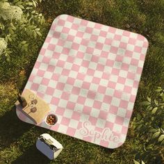 a pink and white checkered picnic blanket with the word sipple next to it