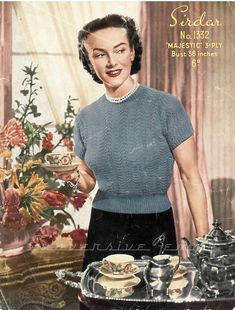 an old photo of a woman holding a tray with tea cups and saucers on it