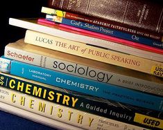 a stack of books sitting next to each other on top of a blue table cloth