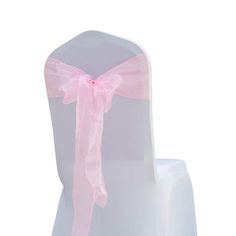 a white chair with pink ribbon tied around the back and seat cover on it's side