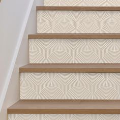 the stairs are decorated with beige and white wallpaper