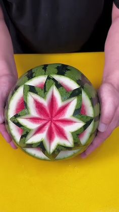 a person is holding a watermelon carved like a flower