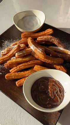 churros and dipping sauce on a wooden tray