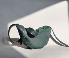 A medium sized sling handbag. Made of very soft fleshy natural leather. Leather high quality  . Dark green, emerald color.  To be worn on a tied belt. The strap is long. The bag can be worn at chest height, a little lower covering the tummy, or completely low like a typical crossbody bag. Details: -Zippered bag -Zippered outer pocket on the back -Inside lining, 1 zip pocket and 1 phone pocket. The widest place, at the very top it is 43 cm wide and the height in the middle is 24 cm The bag holds Green Shoulder Belt Bag For Everyday Use, Green Leather Belt Bag For Daily Use, Everyday Green Shoulder Belt Bag, Green Modern Belt Bag For Everyday Use, Versatile Green Soft Leather Shoulder Bag, Versatile Green Belt Bag For Daily Use, Green Soft Leather Bag For Gift, Green Leather Belt Bag For Everyday Use, Versatile Green Pouch Belt Bag