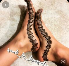 two feet with henna tattoos on them