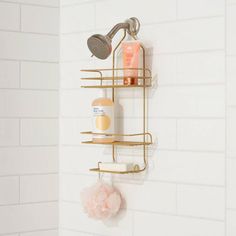 a bathroom shower shelf with soap, lotion and shampoo on it next to a white tiled wall