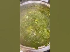 a pot filled with green liquid sitting on top of a stove