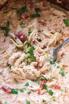 a large pot filled with pasta and meat in sauce, garnished with parsley