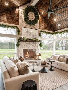 a living room filled with furniture and a fire place in the middle of an open floor plan