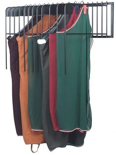 an iron rack with five different colored shirts hanging from it's sides, and two on the other side